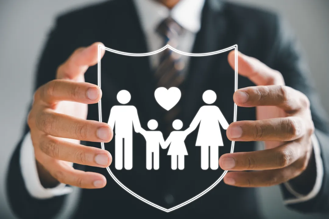 Businessman with protective gesture ensures family security, incorporating life, health, and house coverage